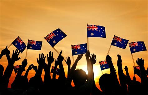 group of people waving australian flags in back lit free image by concert
