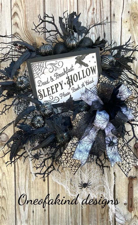 A Black And White Wreath With A Sign That Says Sleepy Hollow On It