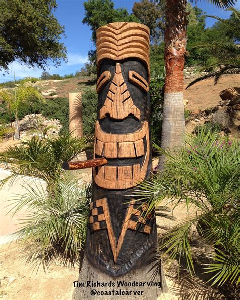 A Carved Totem Stands Next To A Palm Tree