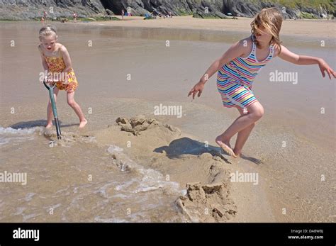 Deux jeunes filles jouant sur une plage à marée montante Photo Stock