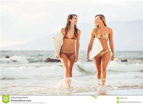 Surfer Girls On The Beach At Sunset In Hawaii Stock Photo