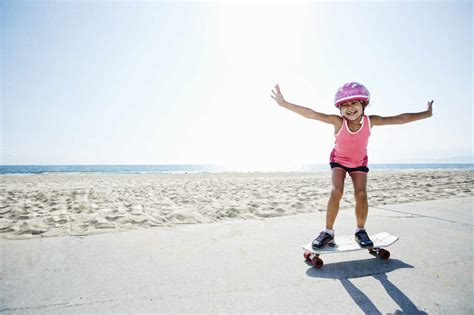 Girl Riding Skateboard At Beach Stock Photo
