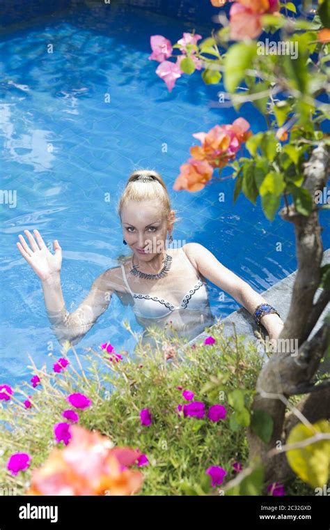 Beautiful Slim Woman In An Open Bathing Suit In The Pool Waves Her Hand At The Camera Shooting