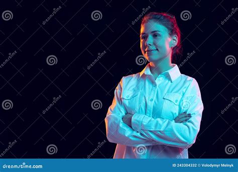 Half Length Portrait Of Young Pretty Girl In White Shirt Isolated On Dark Background In Blue