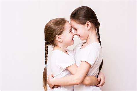 Premium Photo Two Girls Sisters Gently Hug Each Other When Meeting