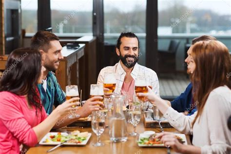 Friends Dining And Drinking Beer At Restaurant Stock Photo By ©syda