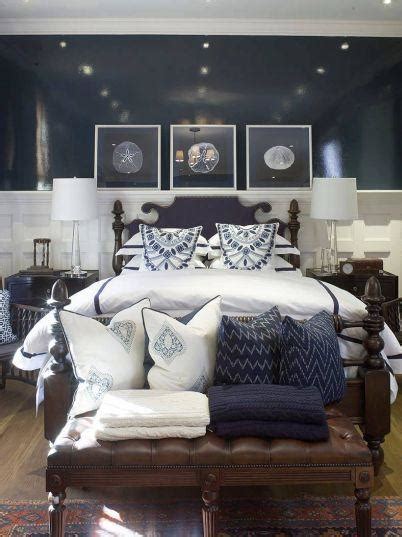 Navy blue wooden bed with a rope nightstand styled with a white lamp in a beige and blue boys cottage bedroom finished with vertical plank walls. webster road: navy + white bedrooms...love!