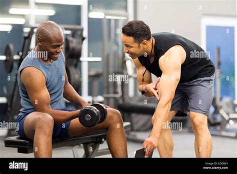 Middle Aged Personal Trainer Training Client In Gym Stock Photo Alamy