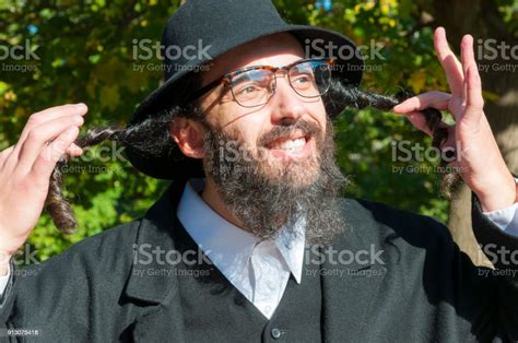 Portrait Of Smiling Orthodox Hasdim Jewish Man Holding Payot Stock