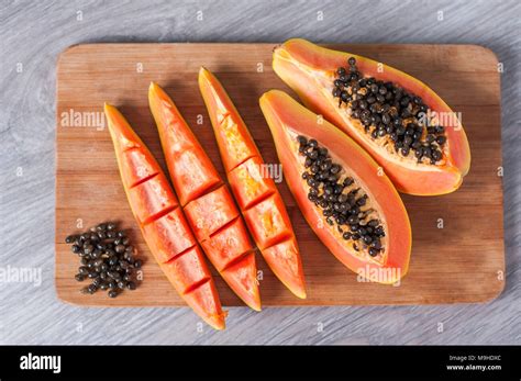 Papaya Fruit Cut In Slices On Wooden Background Stock Photo Alamy