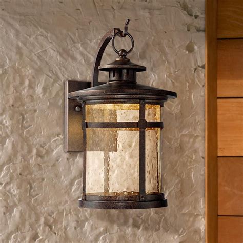 A Light Hanging On The Side Of A Building Next To A Wall With Wood Paneling