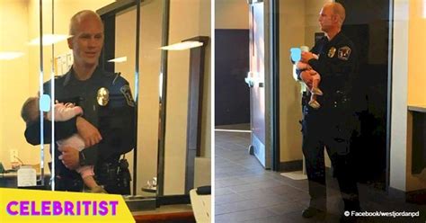 Photo Of Police Officer Holding Baby While Mother Filed Domestic