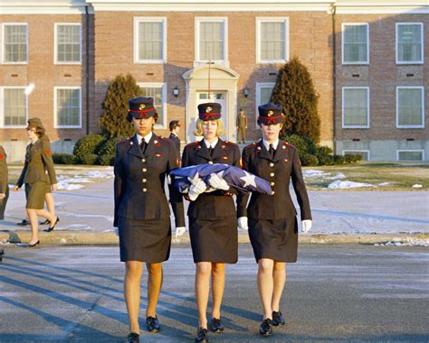 Three Female Marines In Dress Blue Uniforms Raise The