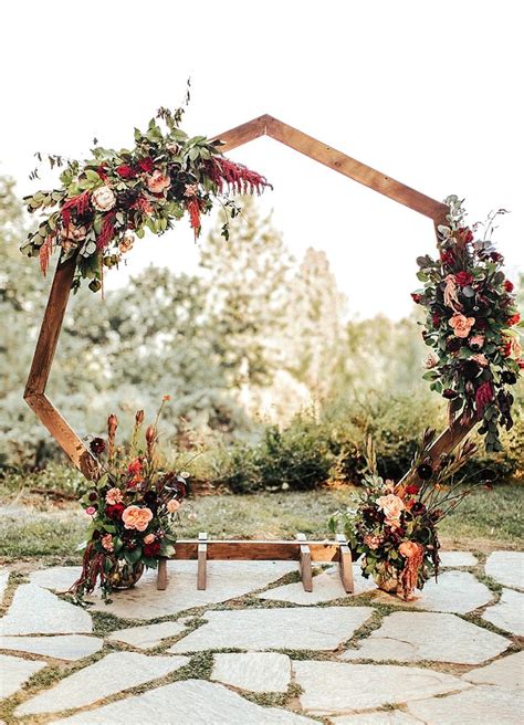 An Outdoor Ceremony Setup With Flowers And Greenery