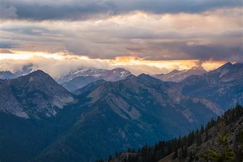 Scenic View Of Mountains Against Dramatic Sky At Sunset · Free Stock Photo