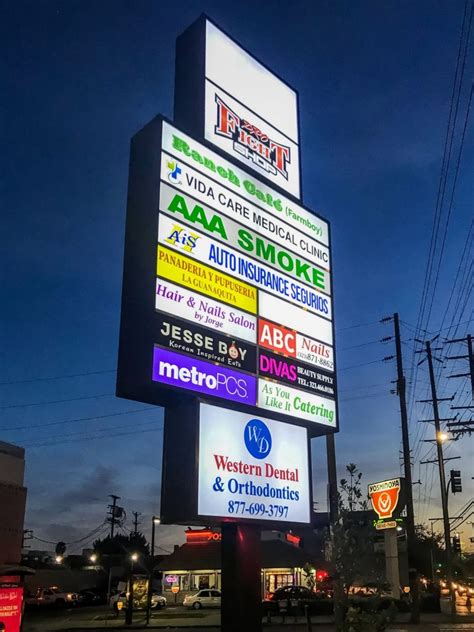 Large Illuminated Pylon Sign With Various Advertisements Front Signs