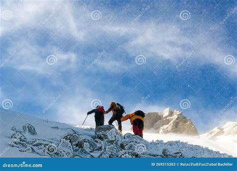 Tree Snow Hikers Climbing A Snowy Mountain During A Snowstorm Stock