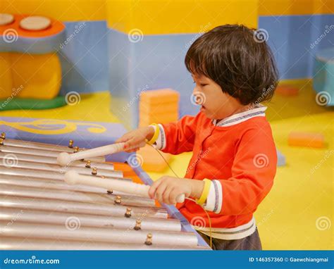 Little Asian Baby Girl Enjoys Playing A Glockenspiel Xylophone Stock