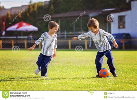 Dos niños protagonizan vídeo viral, jugando futbol. Dos Niños Pequeños Lindos, Jugando A Fútbol Imagen de archivo - Imagen de rojo, familia: 59544173