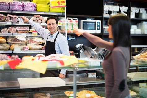 Shopkeeper Cutting Ham In A Grocery Store Premium Photo