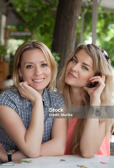 Porträt Von Zwei Junge Schöne Frauen In Der Nähe Von Einem Tisch Zu Sitzen Glückliche Menschen