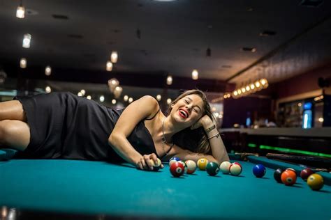 Una Jugadora De Billar Sexy Usa Un Vestido Negro Sobre Una Mesa De Billar Foto Premium