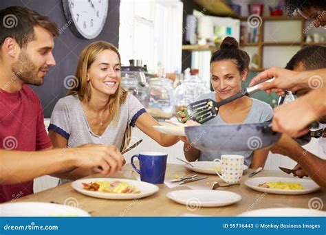 Group Of Friends Enjoying Breakfast In Kitchen Together Stock Image