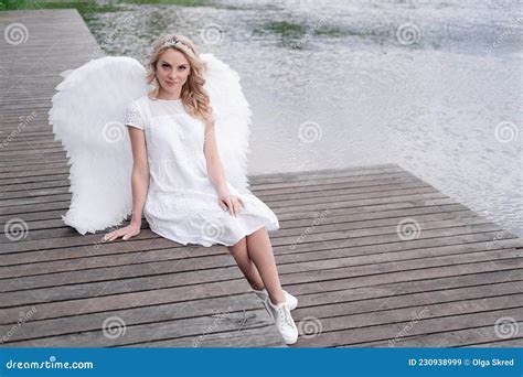 Charming Blonde With White Angel Wings Standing By The Water Beautiful