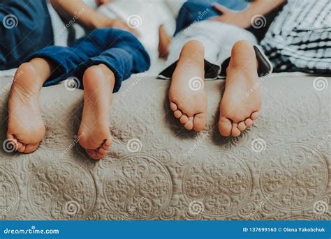 Close Up Of Two Pairs Of Kids Feet In Bed Stock Photo Image Of