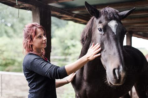 Young Woman Taking Care Of Her Horse By Stocksy Contributor Mauro