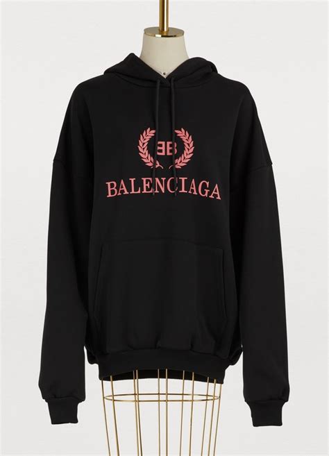 The blue creation is designed with a zip closure, long sleeves, and embroidered logo details on t. Women's BB oversized hoodie | Balenciaga | 24 Sèvres