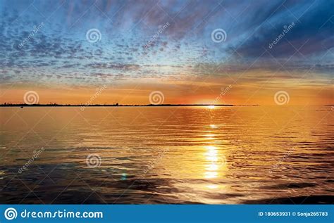 Sunset At Sea Gold Cloudy Skyline And Water Wave Reflection Sunlight