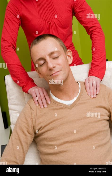 Woman Massaging A Man S Shoulders Stock Photo Alamy