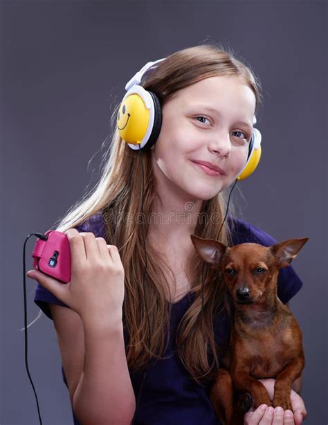 Studio Shot Of A Smiling Teen Girl With Headphones And Doggy Stock