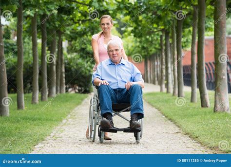 Mujer Con Su Viejo Padre Mayor On Wheelchair Imagen De Archivo Imagen