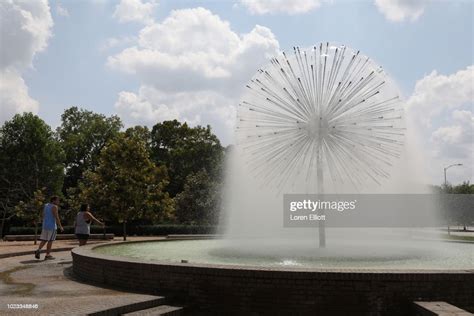 People Walk Past The Gus S Wortham Memorial Fountain By Buffalo