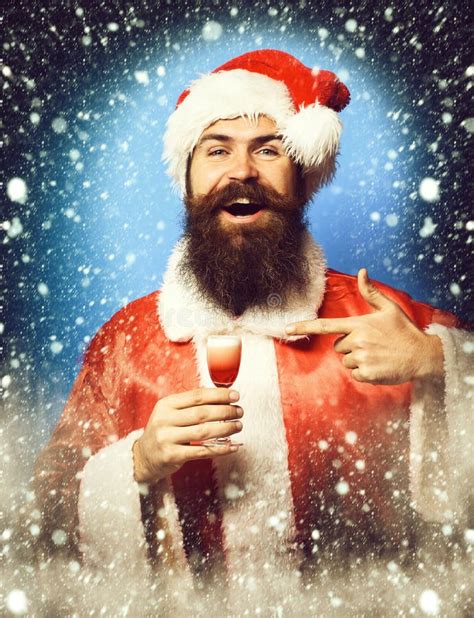 Handsome Bearded Santa Claus Man With Long Beard On Smiling Face Holding Glass Of Alcoholic Shot