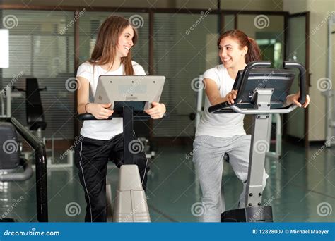 Twee Gelukkige Jonge Vrouwen In Gymnastiek Het Biking Stock Afbeelding Image Of Meisje Slank
