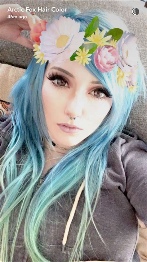a woman with long blue hair and flowers in her hair wearing a flower headband