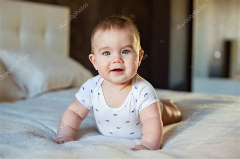 Very Cute Little Baby Boy Lying On The Bed On His Tummy On A Lig Stock