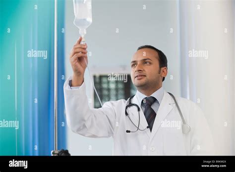 Doctor Checking A Saline Drip Stock Photo Alamy