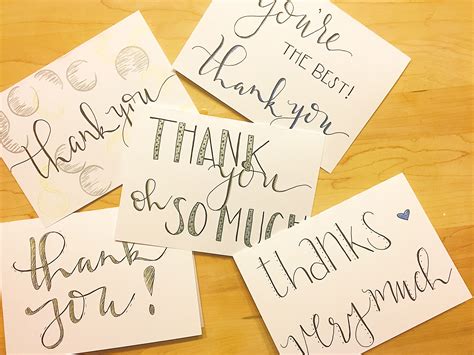 Four Handwritten Thank You Notes Sitting On Top Of A Wooden Table