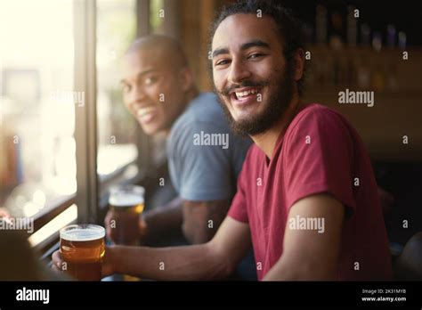 The Fun Is Just Getting Started Portrait Of Two Friends Enjoying Themselves In The Pub Stock