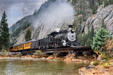 Steam Train Crossing A Trestle Bridge In The Mountains Stock Photo