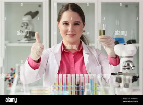 Woman Chemist Holding Test Tubes And Showing Thumbs Up Sign Stock Photo
