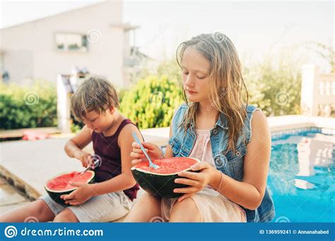 Outdoor Summer Portrait Of Two Funny Kids Eating