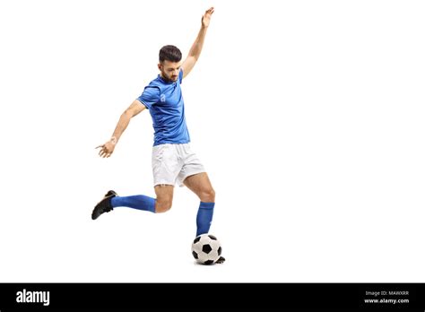 Jugador de fútbol pateando una pelota de fútbol aislado sobre fondo blanco Fotografía de stock