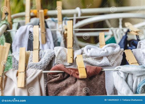 White And Colored Linen To Be Dried On The Clothesline With Wooden