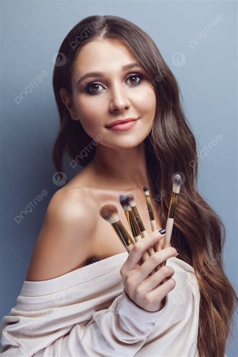 Beautiful Young Woman With Long Hair Holding Different Make Up Brushes