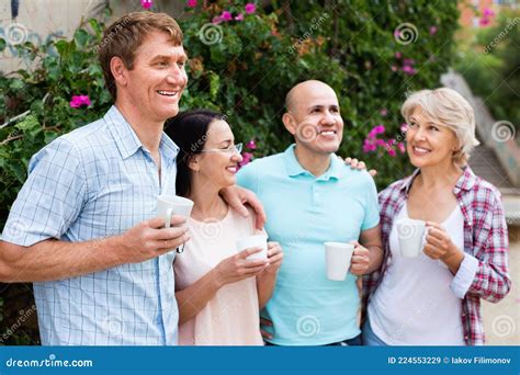 Mature Couples Walking And Drinking Coffee On Holiday Stock Image